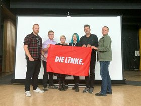 Gruppenbild vom Bezirksvorstand mit LINKE-Fahne